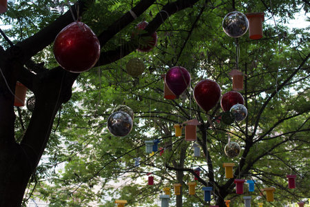 Adorned street trees. There are decorative balls, balloons, lamps and oil lamp