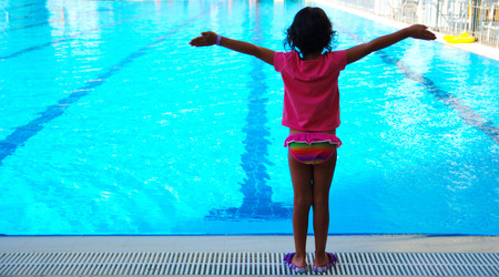 Little girl at the hotel pool. The enjoyment of summer vacation. Very happyの写真素材