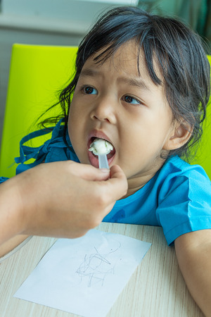 Illness asian kids eating cereal, saline intravenous IV on handの写真素材