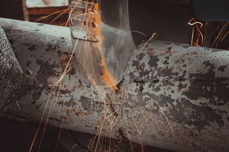 Close-up of Electric Grinder Cutting metal pipe with Bright Sparks tailsの写真素材