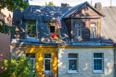 Flowery balcony and rood of old house at sunny day. Vilnius, Lithuaniaの写真素材