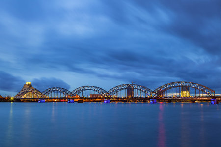 Illuminated railway bridge at night in Riga, Latviaの写真素材