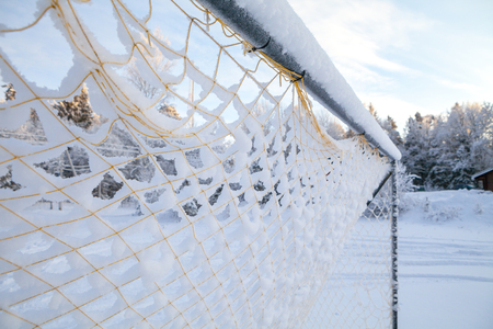 Vintage football goal net, covered with snowの写真素材