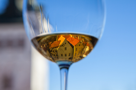 Glasse of white wine with old Tallinn view in reflectionの写真素材