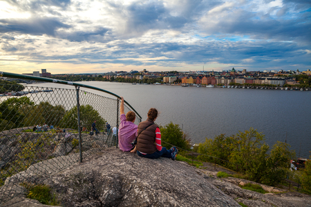 Tourists couple in Stockholm enjoying cityscapes of old town from rockの写真素材