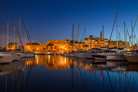 Night view of marina with sail boats and yachts and illuminated architecture. Malta island.の写真素材