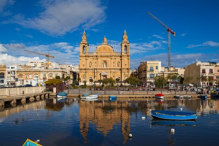 MSIDA, MALTA - OCTOBER 19, 2016: The beautiful Parish Church at sunny day with harbor at the foreground.のeditorial素材
