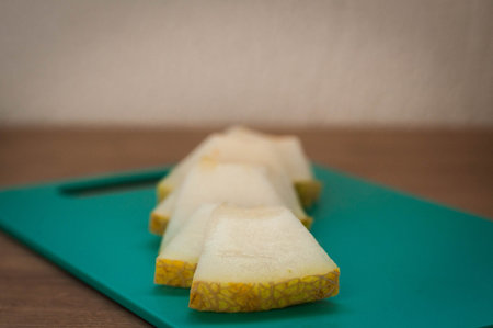 Fresh melon sliced on cutting board on wooden table