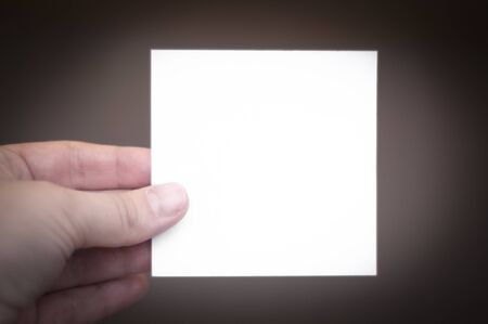 woman hand holding a white business card at blur background.の写真素材
