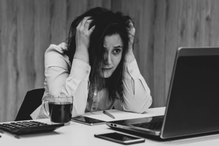 Desperate businesswoman worried hands in the head at office.の写真素材