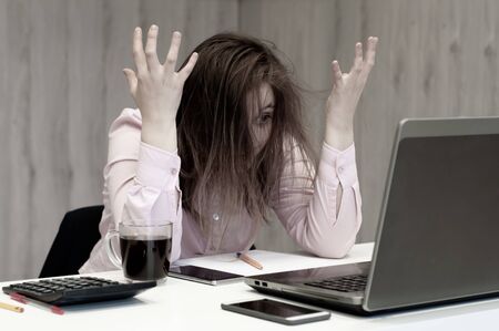 Desperate businesswoman worried hands in the head at office.の写真素材