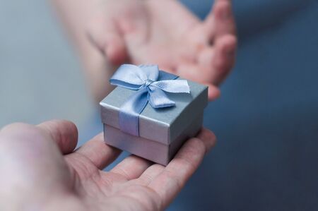 hands giving and receiving a present, close up.の写真素材
