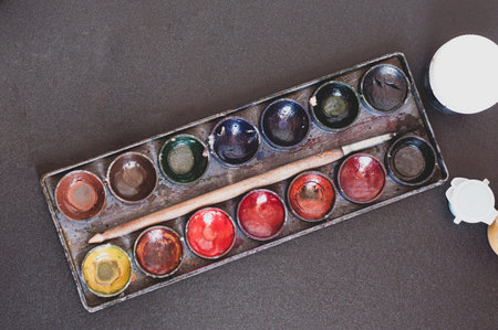 Set of watercolor paint and paintbrush for painting closeup. Top view