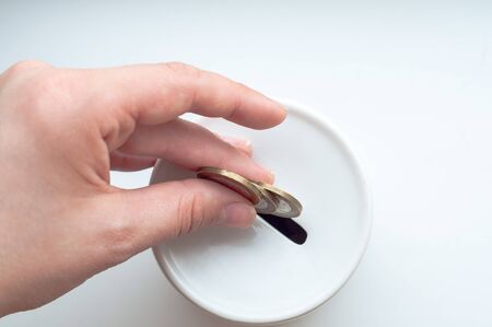 Hand putting coin into the white money boxの写真素材