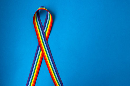 LGBT rainbow ribbon on blue background. Concept of thanks to doctors during a pandemic and hope Let's all be wellの写真素材