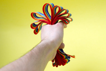 Homophobia. Stop LGBT Pride. Man squeezes in fist rainbow LGBT ribbons in his hand