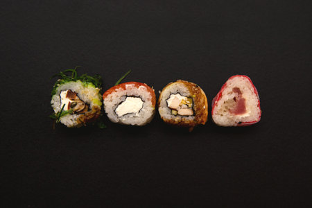 straight parallel vertical lines of sushi and chopstick on black background. sushi rolls patternの写真素材