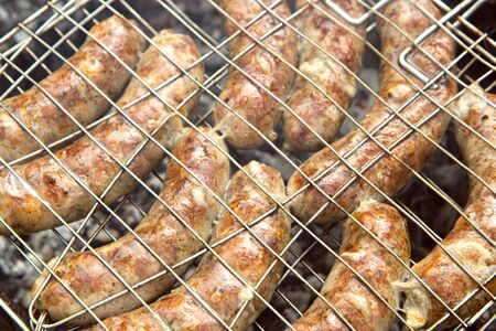 homemade sausages grilled on a barbecue closeup. outdoor picnic food for friends or familyの写真素材