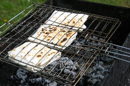 Grilled pita bread on the grill and barbecue. Cooking over charcoal on a picnic.の写真素材