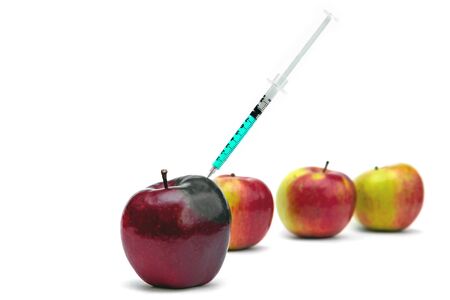 Syringe injection into a red apple. Genetic modified foods, gmo. isolated on white background.の写真素材