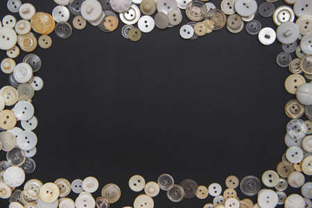 Sewing buttons background. White sewing buttons texture and patterns on black background with copy spaceの写真素材
