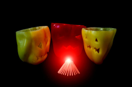 Halloween food. Colorful healthy red and yellow sweet bell peppers with cut out faces in the skin...