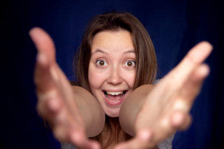 Give me warm hug. Friendly cute woman student pulling hands towards camera, smiling from happiness,...