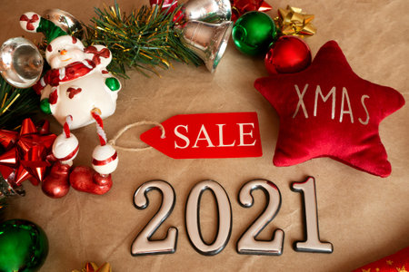 christmas tag with sale on xmas decoration with snowman, christmas toys and balls. flat lay