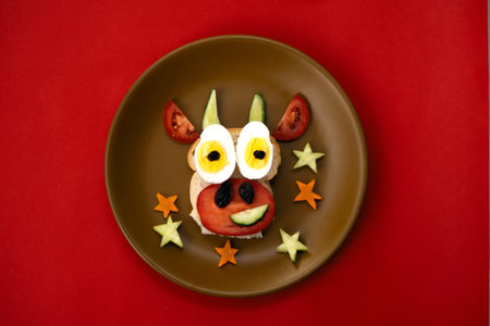 Funny sandwich with edible symbol of 2021 bull cow made from toast bread, cheese, raisins, eggs and...
