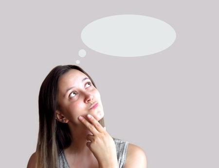 Young woman thinking and looking up to blank bubble speech