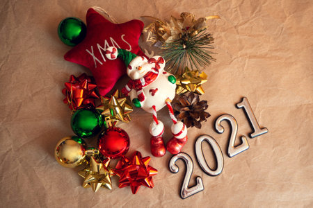 Flat lay composition with Christmas gifts and 2021 festive decor on brown background