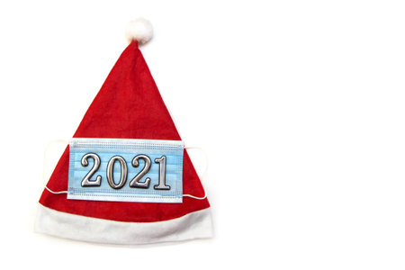 Festive santa hat and medical mask. Creative minimal concept of Christmas and New Year during the...