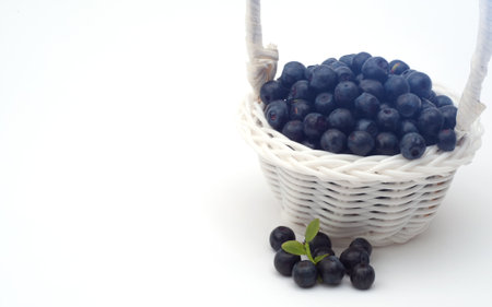 fresh ripe blueberry in wooden basket on table and white background with copy spaceの写真素材