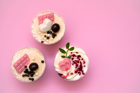 Sweet small homemade trifle dessert with custard, chocolate, nuts and fruits and decorations and cream cheese. Flatly with copy spaceの写真素材
