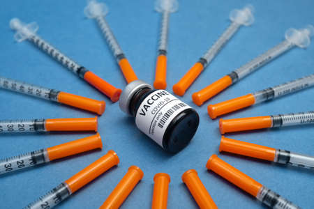 Vaccines and syringes on blue background for prevention, immunization and treatment from corona virus infection covid 19. General vaccination and Healthcare Medical concept, flat layの写真素材