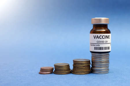 Coronavirus vaccine cost. vaccine ampoule and money. Fight against Covid-19. Pevention, immunization and treatment concept with copy spaceの写真素材