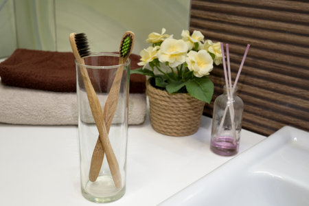 bamboo toothbrush in glass stand with towel in Zero waste bathroom. Plastic free beauty essentials. eco friendly homeの写真素材