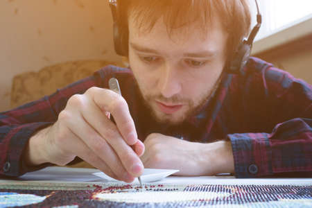 Diamond mosaic collection process. relaxation and rest from work in the process of monotonous activities with music. break for creativity and hobbiesの写真素材
