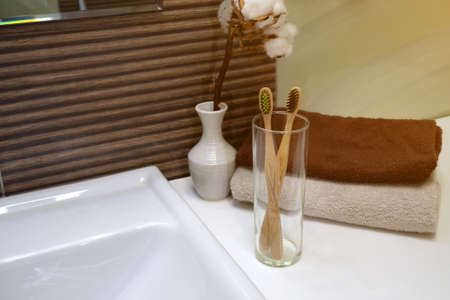 bamboo toothbrush in glass stand with towel in Zero waste bathroom. Plastic free beauty essentials. eco friendly homeの写真素材