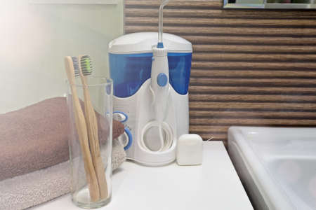 Tools for cleaning teeth in the bathroom. Irrigator and dental floss with bamboo eco toothbrushes. Zero waste, sustainable bathroom and lifestyle.の写真素材