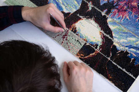 Diamond mosaic collection process. relaxation and rest from work in the process of monotonous activities. break for creativity and hobbiesの写真素材