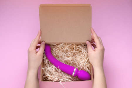 Sex toy pink dildo or vibrator in craft box. Online shopping and delivery, Flat lay.の写真素材