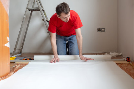 Man repair measures the length of the strip of wallpaper. renovation apartment