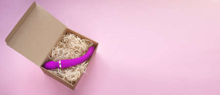 Sex toy pink dildo in craft box. Online shopping and delivery, Flat lay banner with copy space