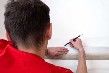 Man repair measures the length of the strip of wallpaper. renovation apartment
