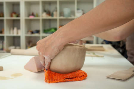 Woman hand potter making clay cup in pottery workshop studio. Process of creating ceramic mug. Handmade, hobby art and handicraft concept.の写真素材