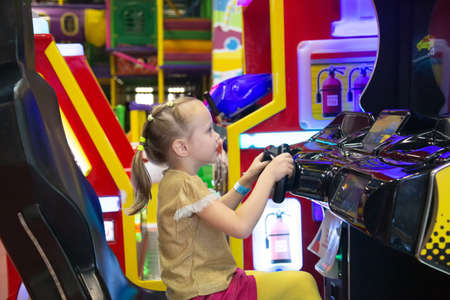 Little girl play in console game with ball in the mall for childrenの写真素材