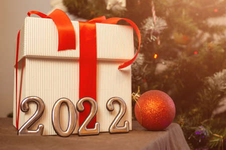 Retro vintage style gift box with new year number 2022 holiday and christmas tree on background