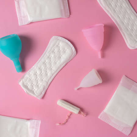 Different types of feminine menstrual hygiene materials products such as pads cloths tampons and cups. Pink backgroundの写真素材