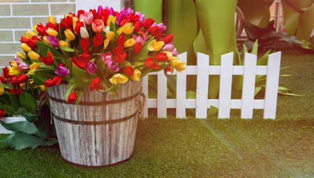 artificial fake tulips flowers in a basket for decoration. concept of wedding and valentines day or international womens day. banner with copy space and place for textの写真素材